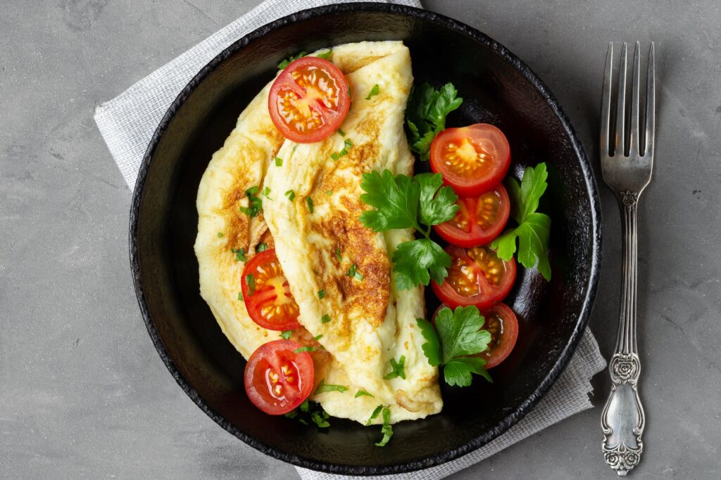 Omlet z dojrzałym pomidorem i świeżymi listkami bazylii